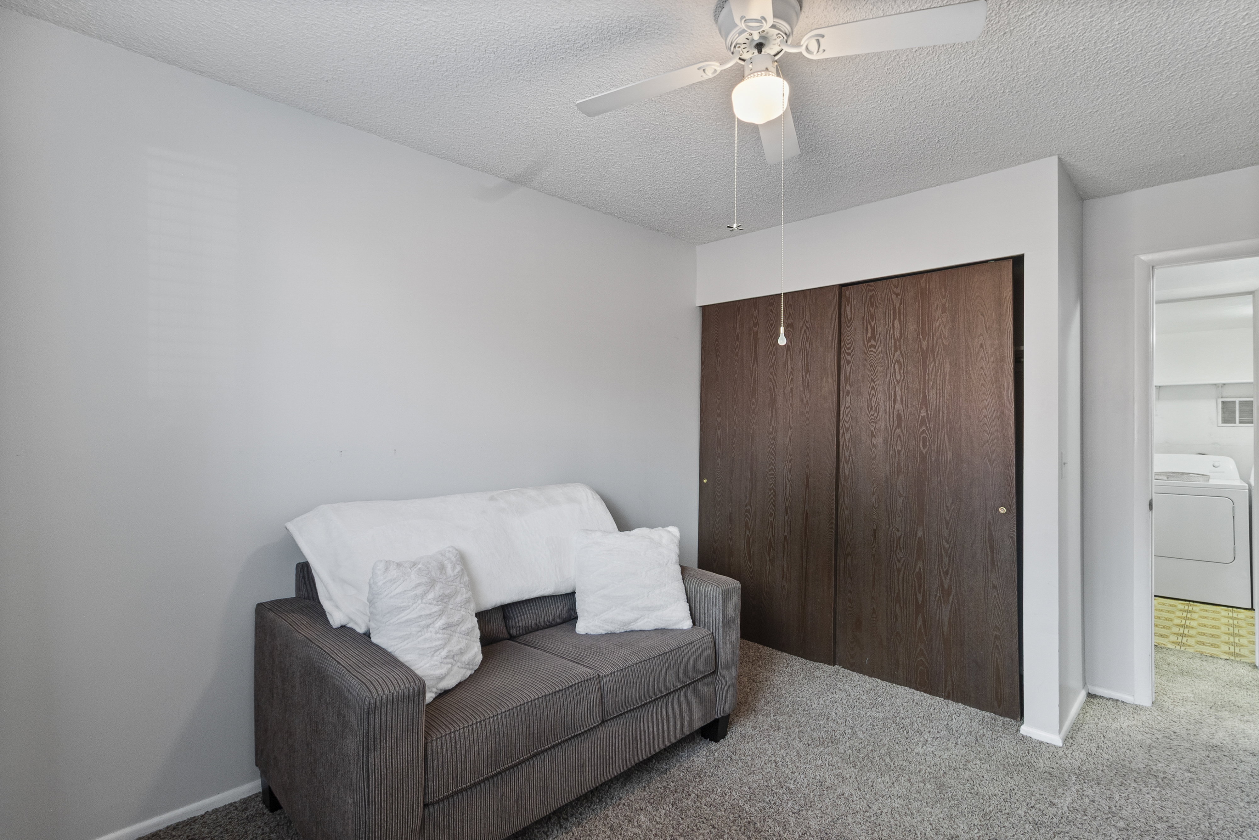 Sitting room featuring carpet flooring, washer / dryer, a textured ceiling, and a ceiling fan