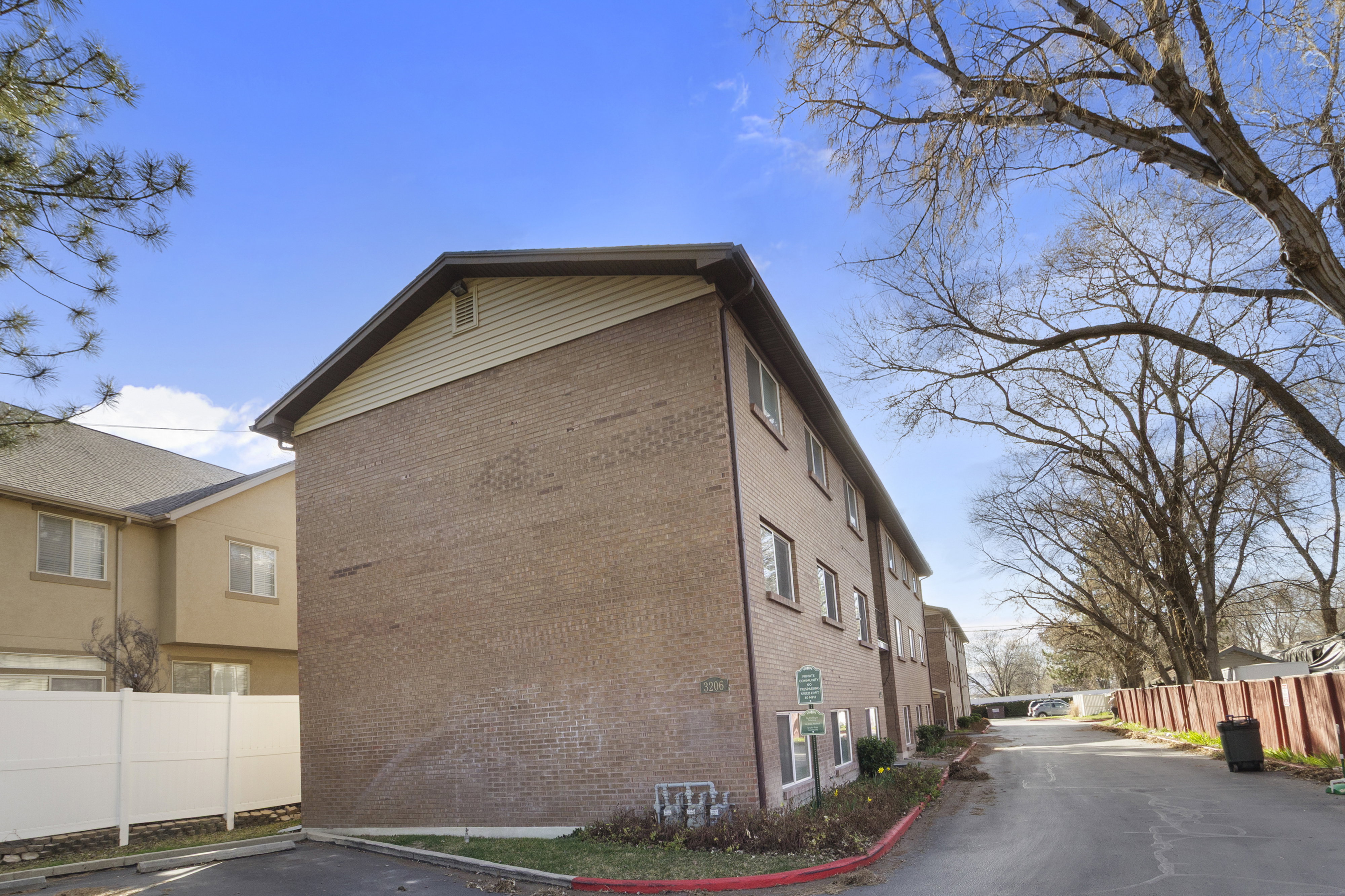 View of home's exterior with brick siding and uncovered parking
