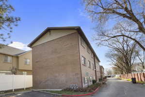View of home's exterior with brick siding and uncovered parking