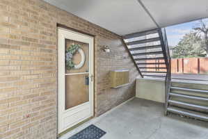 Entrance to property with brick siding and a patio