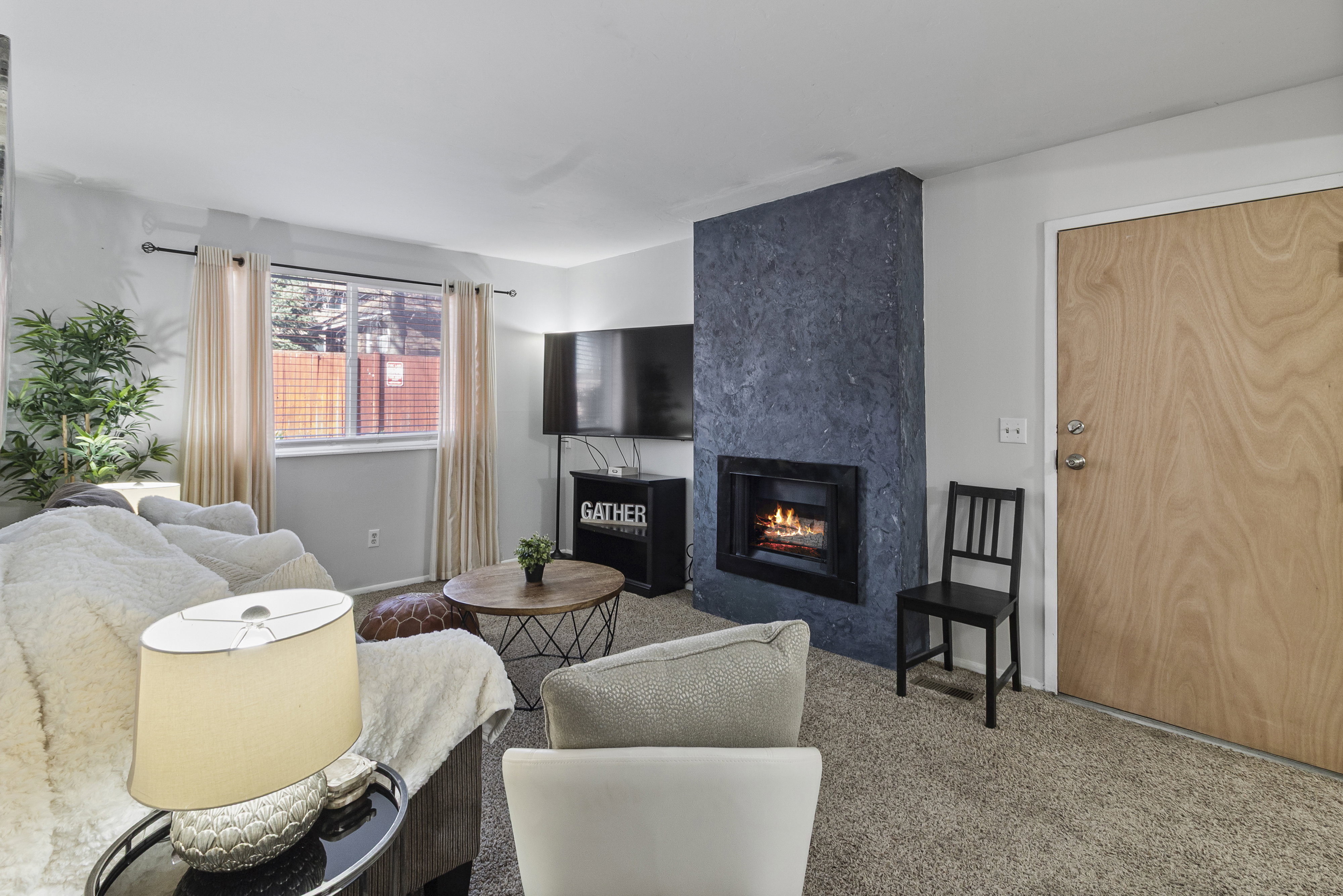 Living area with a premium fireplace and carpet