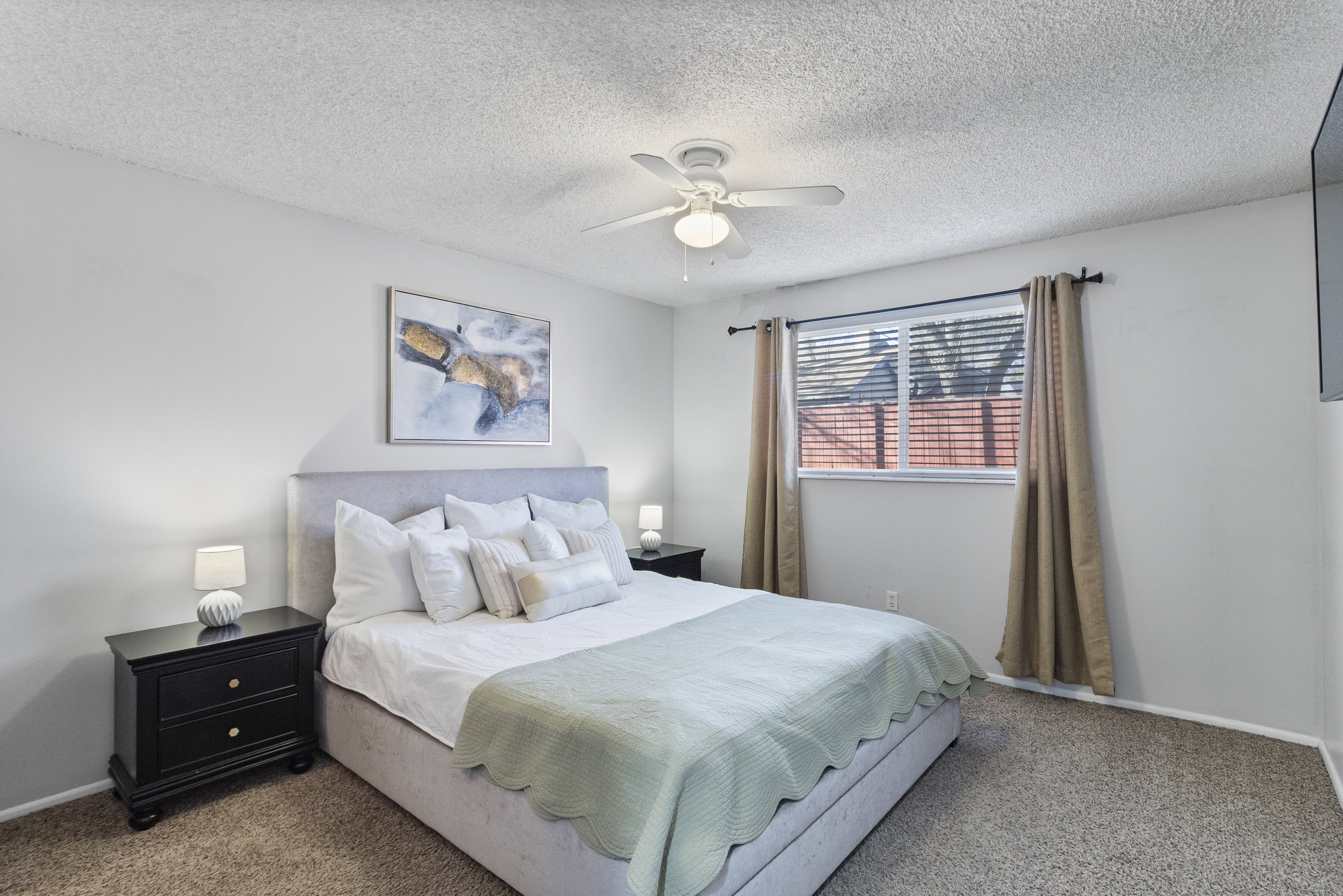 Bedroom featuring carpet, a ceiling fan, and a textured ceiling
