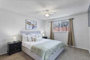 Bedroom featuring carpet, a ceiling fan, and a textured ceiling