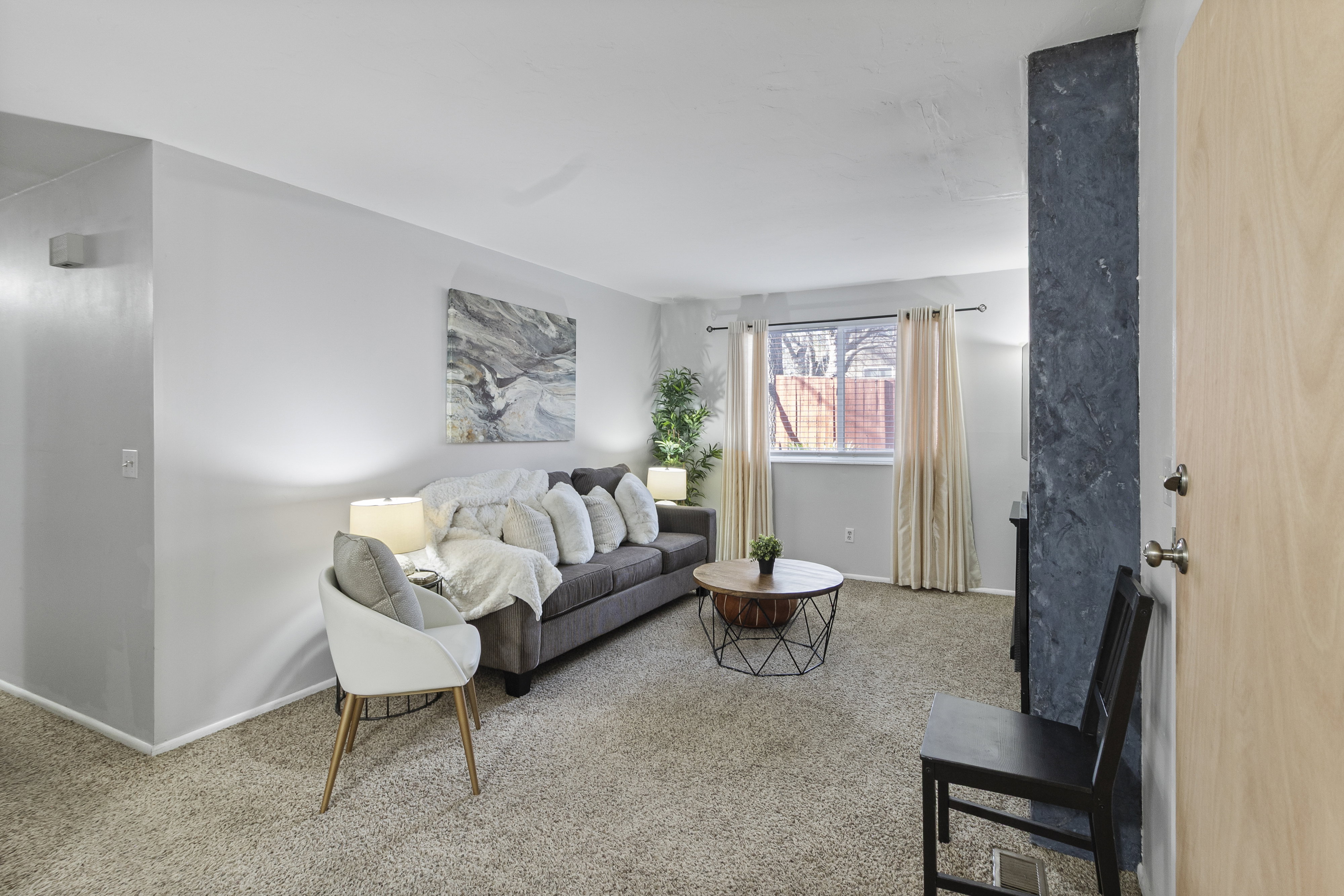 Living room with light colored carpet and baseboards