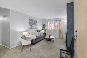 Living room with light colored carpet and baseboards
