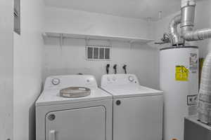 Laundry room with water heater and washing machine and dryer