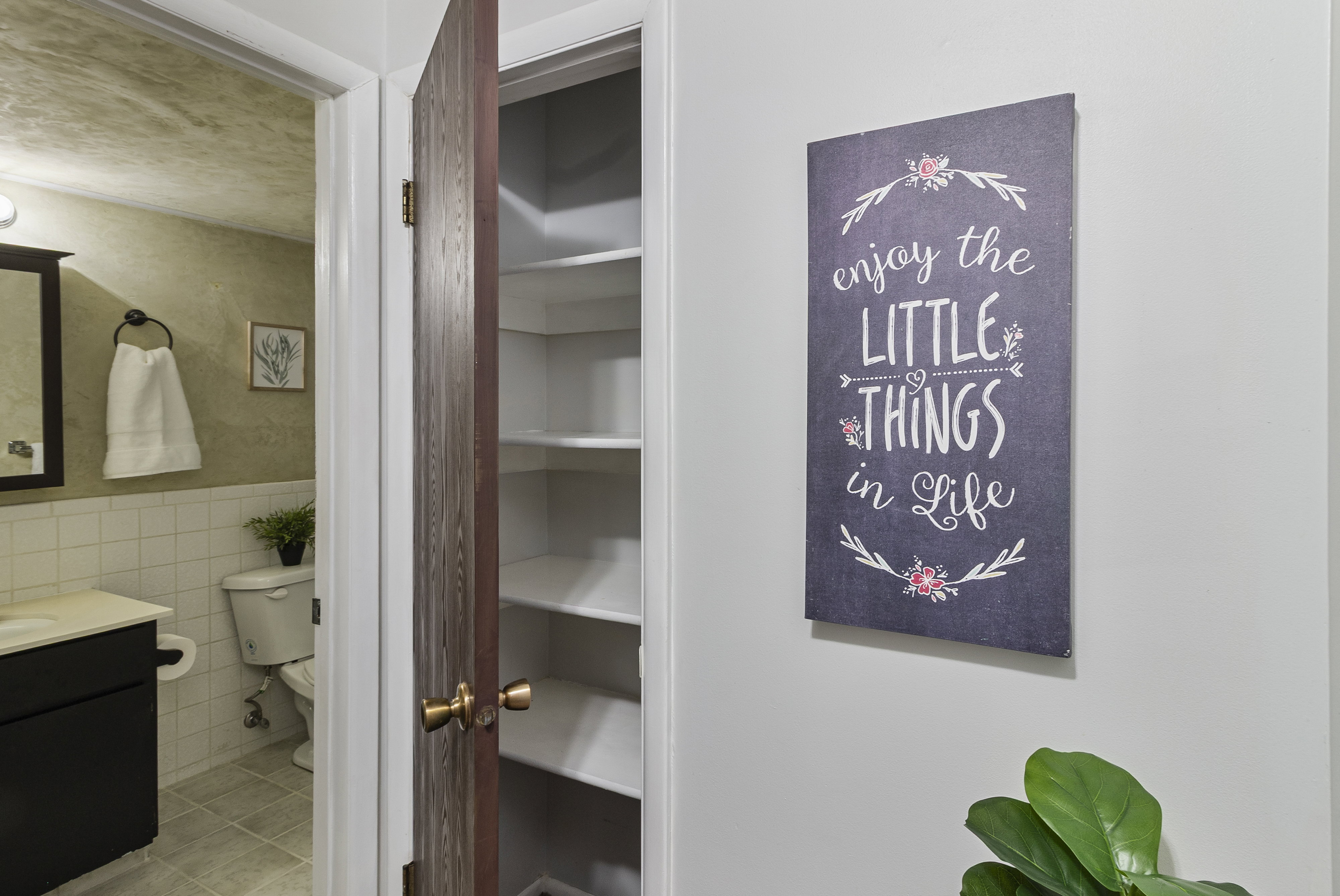 Bathroom view of vanity, tile walls, a closet, and a wainscoted wall
