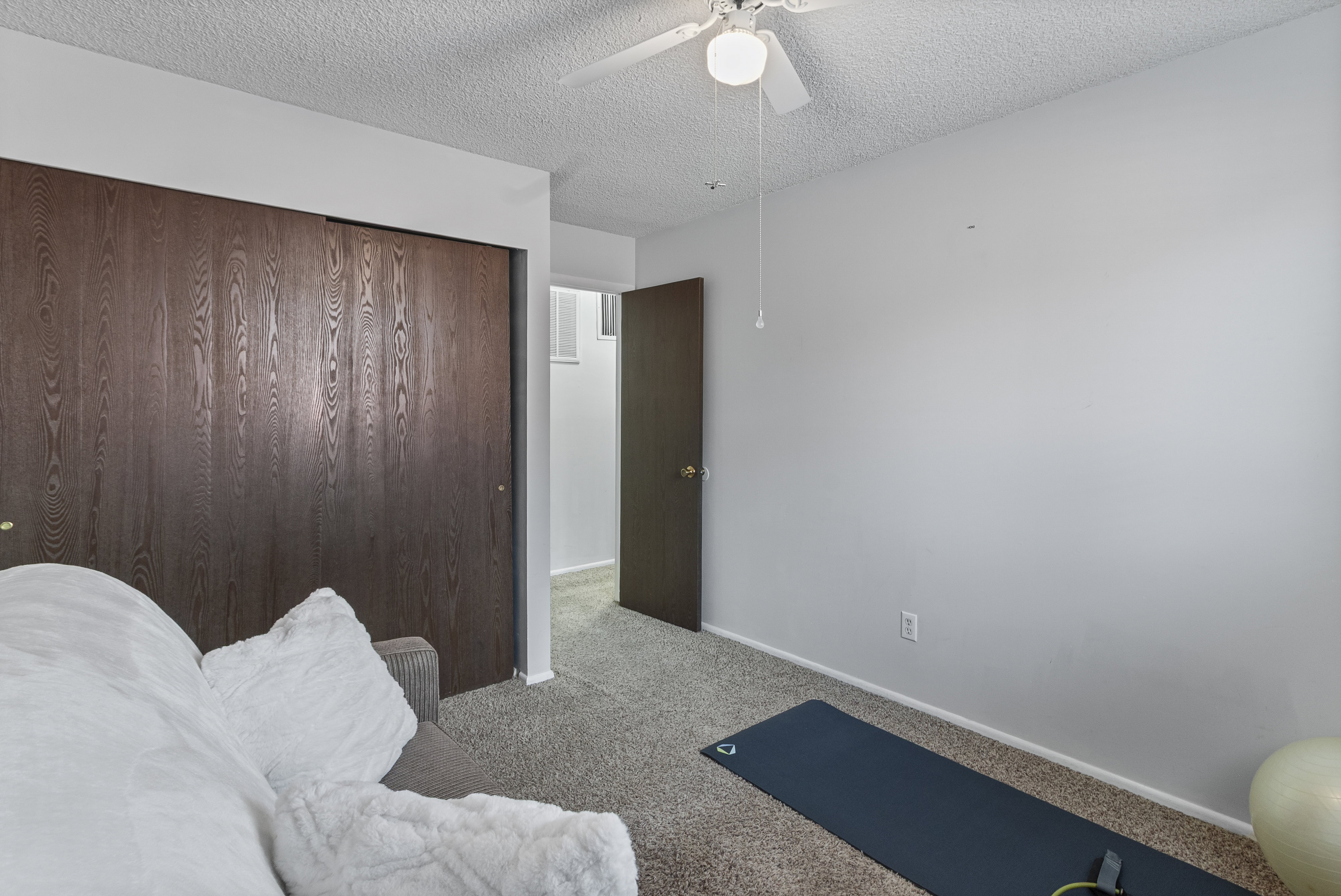 Bedroom featuring carpet flooring, a textured ceiling, a ceiling fan, and a closet
