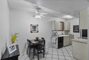 Kitchen with light countertops, a ceiling fan, freestanding refrigerator, dishwasher, and light tile patterned floors