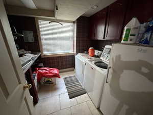 Laundry area featuring cabinet space, separate washer and dryer, and light tile patterned floors