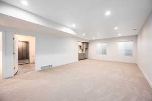 Unfurnished living room featuring light carpet and recessed lighting