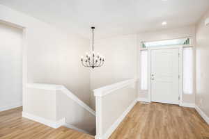 Foyer featuring light wood-style flooring and hanging lights