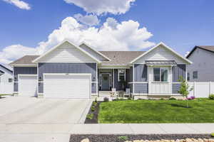 Ranch-style house with board and batten siding, a garage, driveway, covered porch, and roof with shingles