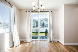 Unfurnished dining area featuring suspended lighting and light wood-style flooring