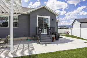 Rear view of house with a patio, a fenced backyard, and roof with shingles