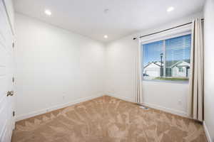 Empty room featuring light colored carpet and recessed lighting