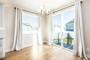 Unfurnished dining area with light wood finished floors and a chandelier