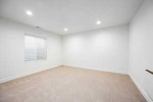 Spare room featuring light colored carpet and recessed lighting