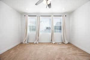 Empty room with light carpet and ceiling fan