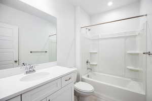 Bathroom with vanity, bathtub / shower combination, and recessed lighting