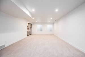 Unfurnished room with light colored carpet and recessed lighting