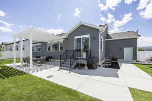 Rear view of property with a patio area, a shingled roof, a pergola, and a gate