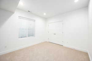 Unfurnished bedroom featuring carpet flooring, recessed lighting, and a closet