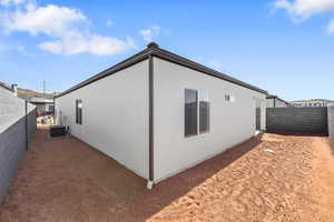 View of side of home with a fenced backyard and stucco siding