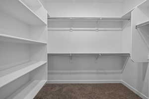 Walk in closet featuring dark carpet