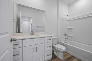 Full bathroom featuring vanity, dark wood-style flooring, and shower / bath combination