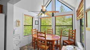 Dining room featuring a ceiling fan and stone finish floors