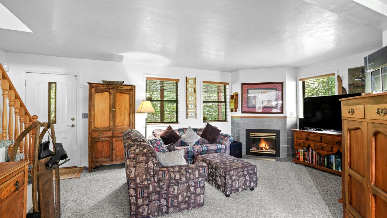 Living room with a tile fireplace and light colored carpet