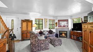 Living room with a tile fireplace and light colored carpet