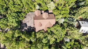 View of subject property featuring a tree filled landscape