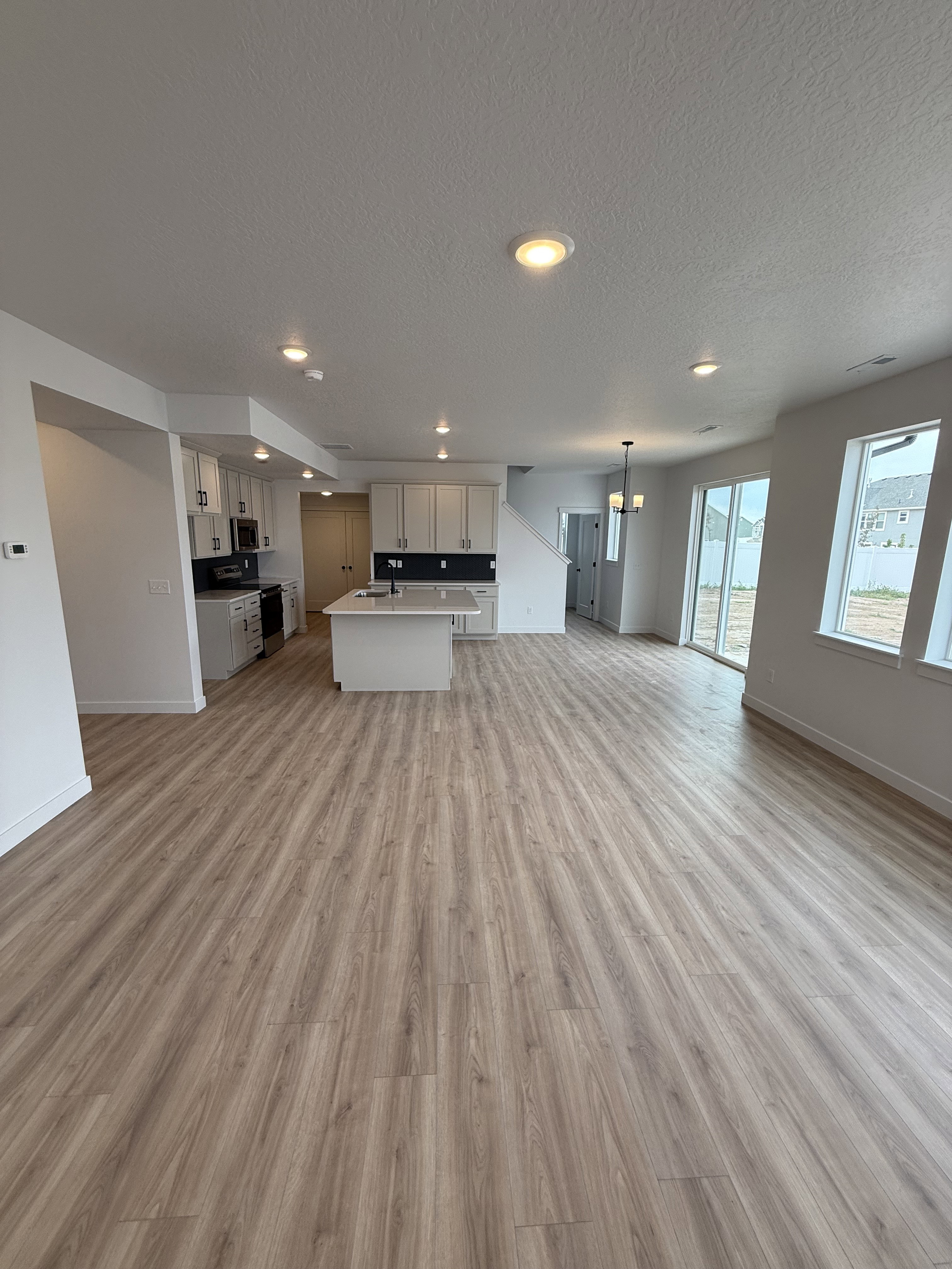 Open-concept living space with light wood-finish flooring