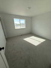 Carpeted empty room featuring baseboards and a textured ceiling