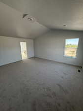 Primary bedroom with vaulted ceiling.