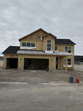 Property under construction with dirt driveway, a shingled roof, and a garage