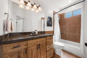 Full bath featuring vanity, shower / bath combination with curtain, and tile patterned flooring