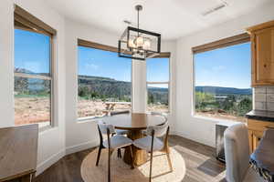 Dining room featuring a mountain view, wood finished floors, and suspended lighting