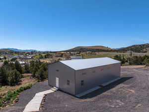 View of home's exterior featuring a metal roof, a mountain view, an outdoor structure, and a rural view