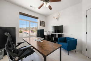 Office area with light colored carpet and ceiling fan