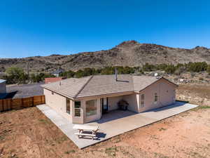 Back of house with stucco siding, a mountain view, and a patio area