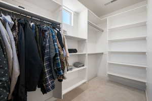 Walk in closet featuring light colored carpet