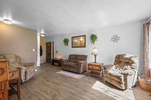 Living area with wood finished floors and a textured ceiling
