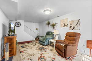 Sitting room with a textured ceiling and baseboards