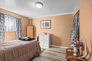 Bedroom featuring a textured ceiling and light wood finished floors