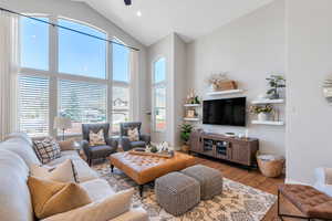 Living area with wood finished floors, vaulted ceiling, and recessed lighting