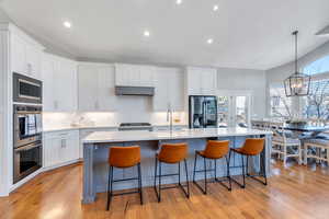 Kitchen with , stainless steel appliances, custom  cabinetry, a kitchen breakfast bar, and an island with sink