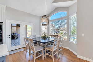 Dining room with hardwood floors, vaulted ceiling,  and chandelier